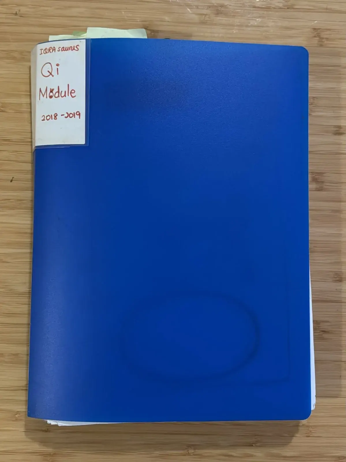 A blue document folder with a hand-written label: IQRAsaurus Qi Module 2018-2019